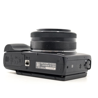 Máquina fotográfica digital preta com lente destacada no fundo branco