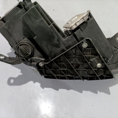 Componente automóvel preto com textura plástica e metálica sobre fundo branco