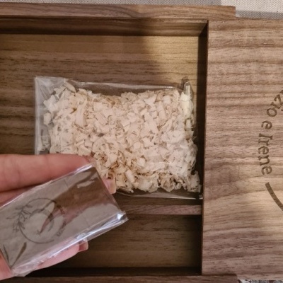 Caixa de madeira com serradura de madeira e pacote prateado com selo