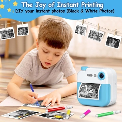 Criança desenhando com marcadores ao lado de impressora instantânea azul e branca que imprime fotos a preto e branco