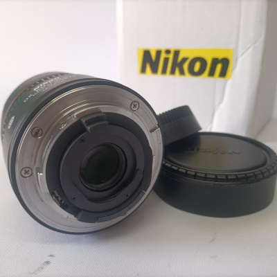 Objetiva fotográfica Nikon com tampa e embalagem