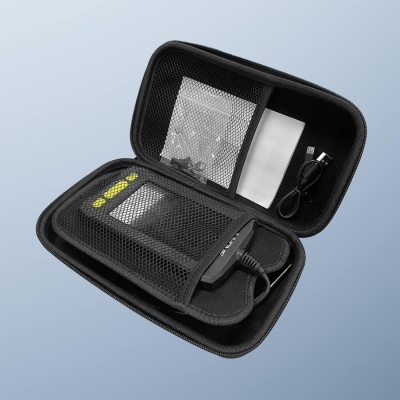 Estojo preto aberto com dispositivo eletrônico, cabo USB, sacos plásticos e papel