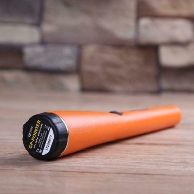 Detector de metais Gopointer laranja e preto sobre madeira