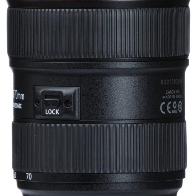 Lente fotográfica Canon preta com anel vermelho e texto branco.