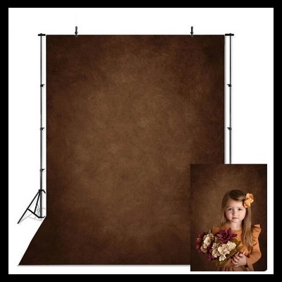 Fundo fotográfico de tecido marrom com menina a segurar flores secas