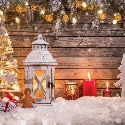 Decoração natalícia com árvores de luzes, lanternas, velas, boneco de gengibre e presentes sobre neve artificial