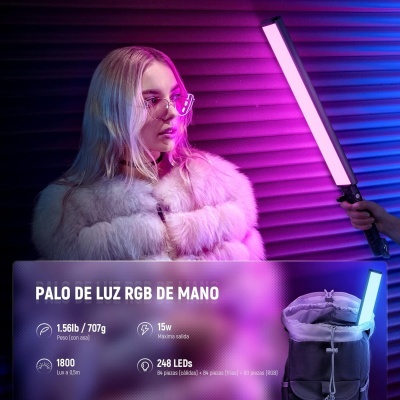 Mulher com casaco branco e óculos segurando barra de luz RGB colorida