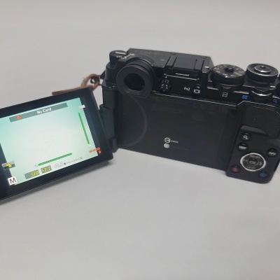 Câmara digital preta com ecrã articulado e alça em pele castanha