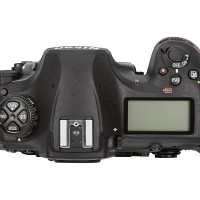 Parte superior de câmara fotográfica digital preta com botões e ecrã LCD