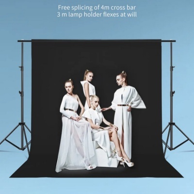 Estúdio fotográfico com fundo preto e quatro modelos femininas vestindo vestidos brancos.