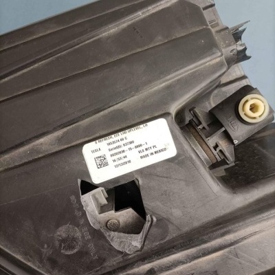 Peça plástica preta com etiqueta branca e texto com códigos e QR code