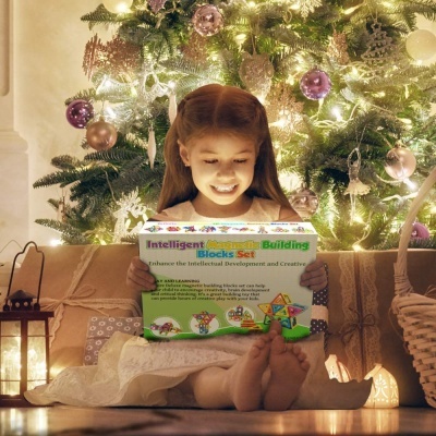 Criança sorridente segurando caixa de brinquedo 