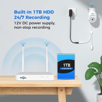 Sistema de vigilância com câmara, router com antenas, e disco HDD 1TB sobre mesa de madeira.