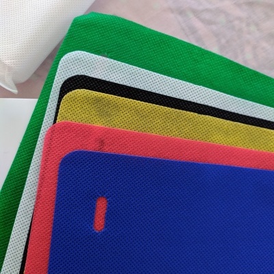 Tecidos coloridos empilhados de malha sintética e tecido branco enrolado