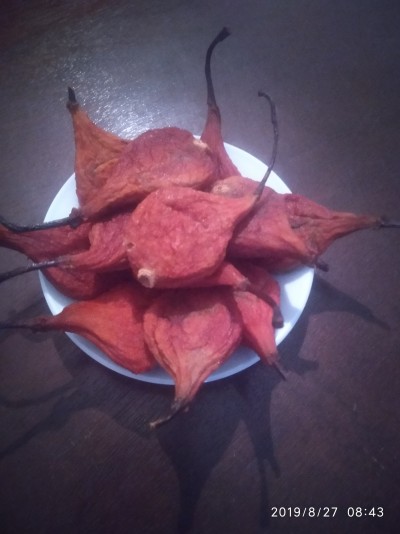 Frutos secos vermelhos com caules num prato branco