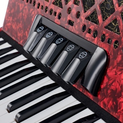 Teclado de acordeão vermelho com teclas e botões pretos e brancos