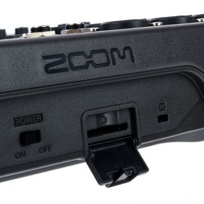 Dispositivo eletrônico preto com interruptor e porta aberta com marca ZOOM em relevo