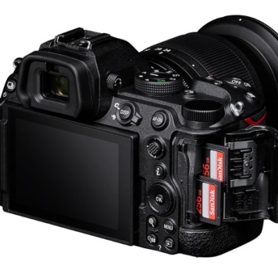 Câmara digital preta com ecrã, lente, vários botões e cartões SanDisk na ranhura lateral aberta