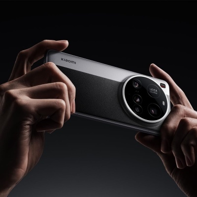 Smartphone Xiaomi cinzento e preto com câmara circular Leica segurado por mãos