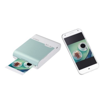 Impressora portátil Canon a imprimir foto ao lado de smartphone branco com mesma imagem