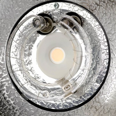 Lâmpada circular fluorescente numa luminária prateada texturizada