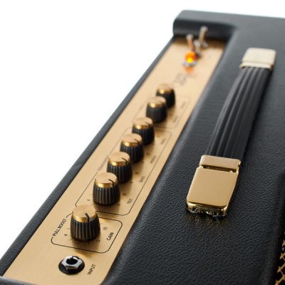 Amplificador de guitarra preto com painel dourado e botões de ajuste