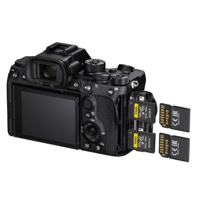 Câmara fotográfica digital preta com ecrã LCD traseiro e cartões SDXC inseridos no compartimento lateral