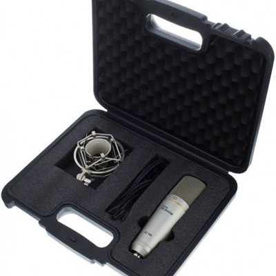 Estojo preto aberto com interior em espuma e microfone condensador prateado, suporte metálico e cabo preto