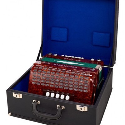 Acordeão vermelho marmorizado em mala preta aberta com interior azul