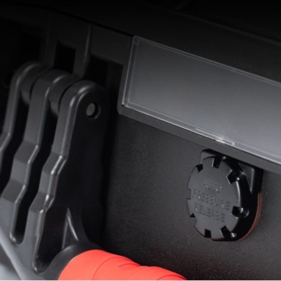 Peça de equipamento preto e vermelho com válvula de pressão de ar em destaque