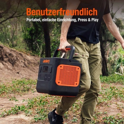 Unidade portátil de energia Jackery preta com detalhes em laranja e alça de transporte