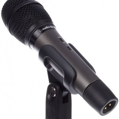 Microfone preto de mão com proteção em malha metálica e suporte plástico