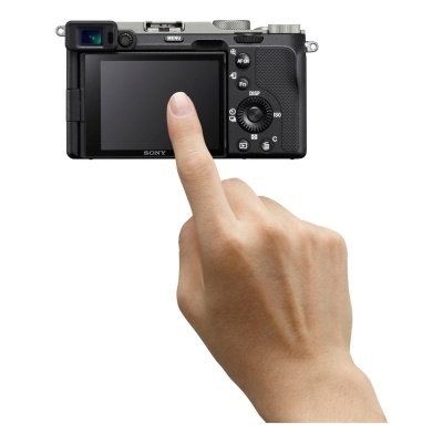 Câmara digital compacta Sony preta com ecrã LCD e uma mão a tocar no ecrã