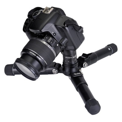 Câmera digital preta numa tripé pequeno preto sobre fundo branco