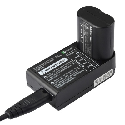 Carregador de bateria preto com uma bateria inserida e cabo ligado