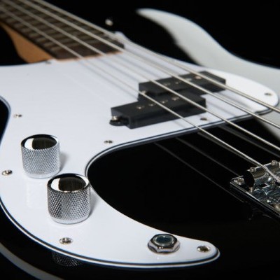 Guitarra elétrica preta com pickguard branco e detalhes metálicos