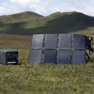 Painel solar portátil e gerador num campo verde com colinas