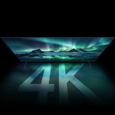 Televisão ultra-fina a exibir paisagem de aurora boreal com texto 4K iluminado no chão