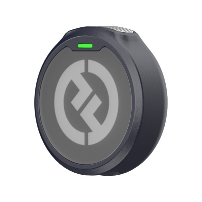 Dispositivo eletrônico redondo cinzento escuro com símbolo circular e indicador luminoso verde