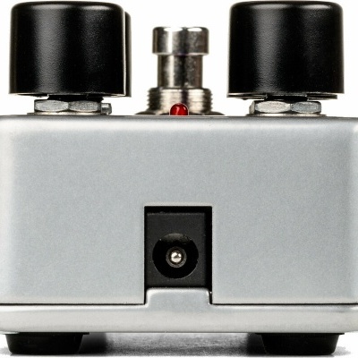 Pedal de guitarra metálico prateado com botões pretos e interruptor