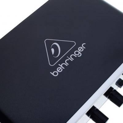 Interface de áudio preta com botões de ajuste e logo behringer