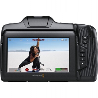 Câmara digital preta Blackmagic com ecrã LCD a cores a mostrar uma mulher a fazer exercício no deserto.
