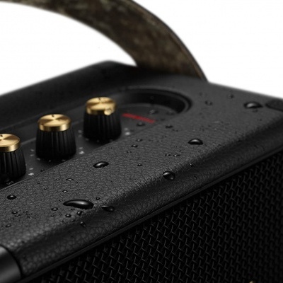 aparelho de som preto com botões dourados e gotas de água