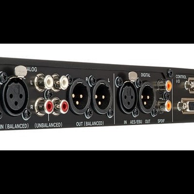 Painel traseiro de equipamento áudio profissional com vários conectores e texto branco.