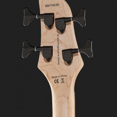 Parte traseira da cabeça de guitarra elétrica em madeira clara com tarraxas pretas e texto impresso