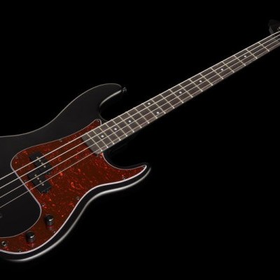 Baixo elétrico preto com escudo vermelho marmoreado em fundo preto.