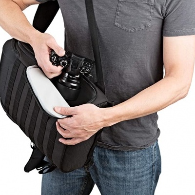 Bolsa de câmeras preta e homem a retirar câmara fotográfica