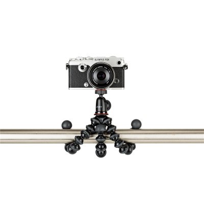 Câmara Olympus PEN branca com tripé flexível em corrimão metálico