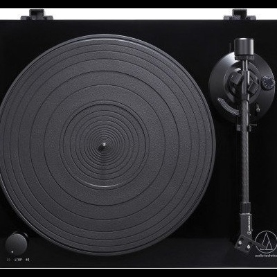 Gira-discos preto com prato circular texturizado e braço de leitura