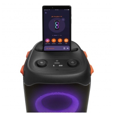 Coluna de som JBL PartyBox 110 preta com iluminação roxa e smartphone em cima
